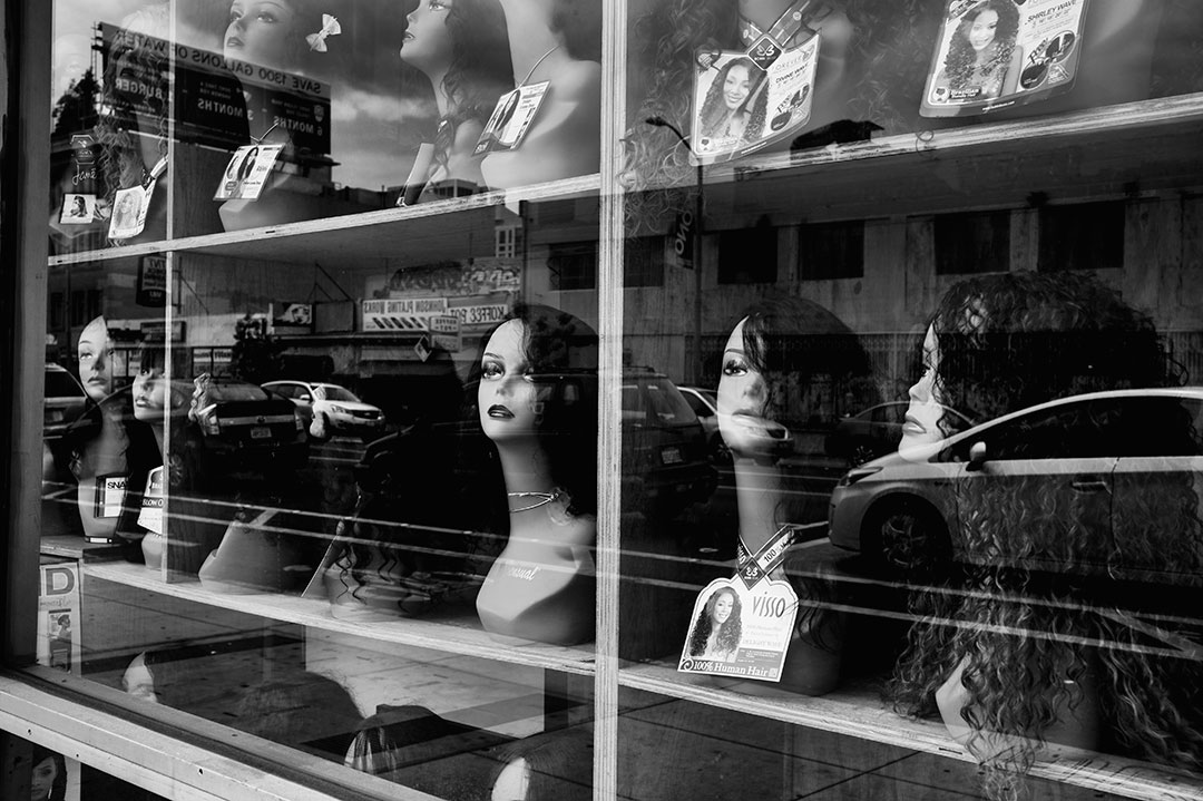 Wig shop mannequins in store window in Oakland, California in 2017.