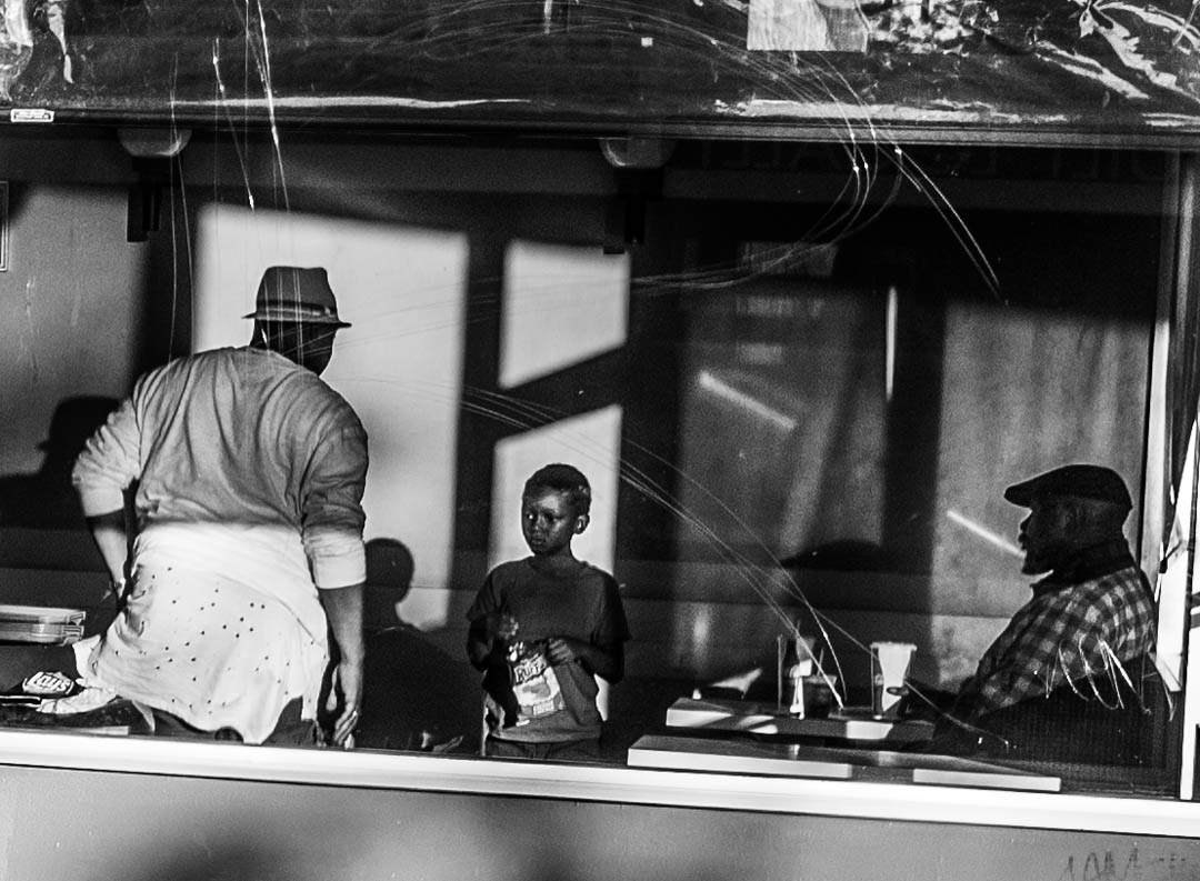 Two men and a young boy in an Oakland, California fast food restaurant in 2017.