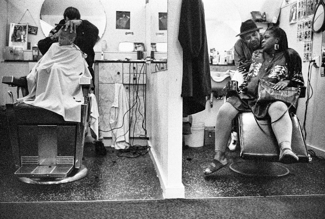 Cubicle views of customers in a San Francisco barbershop in 1994.